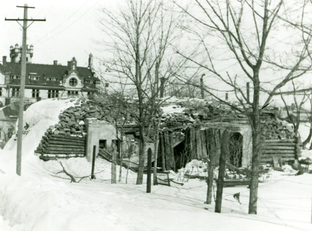 Punkkeri, jota ympäröi piikkilanka. Taustalla Regattahotelli. On lumista. En bunker som omringas av taggtråd. I bakgrunden hotell Regatta. Det är snö på marken. A bunker surrounded with barb wire. In the background the Regatta hotel. There's snow.
