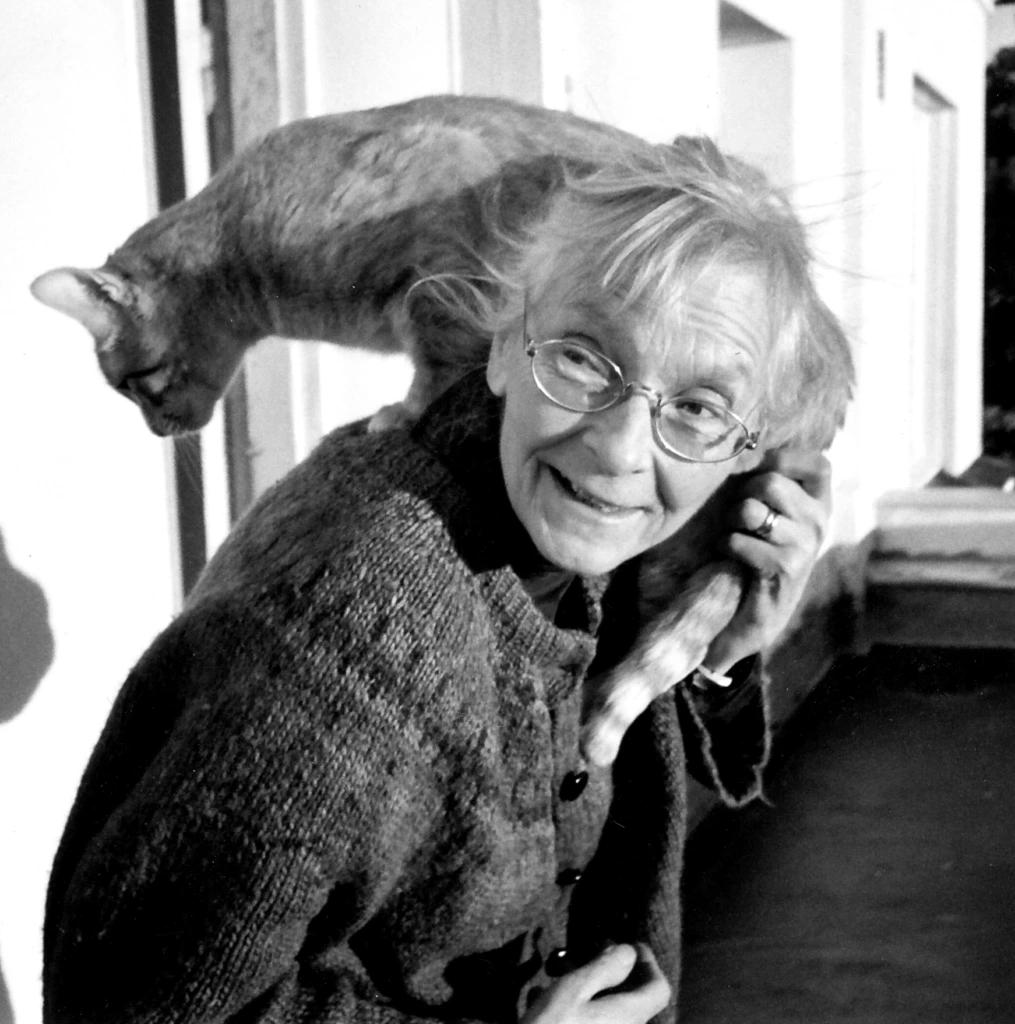 vanhempi nainen kissa olkapäillään